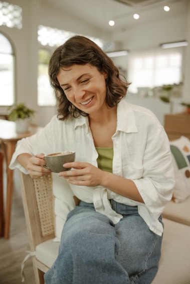 a woman sitting on a chair holding a bowl of food