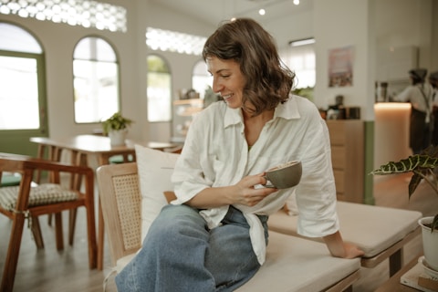 a woman sitting on a bench holding a bowl