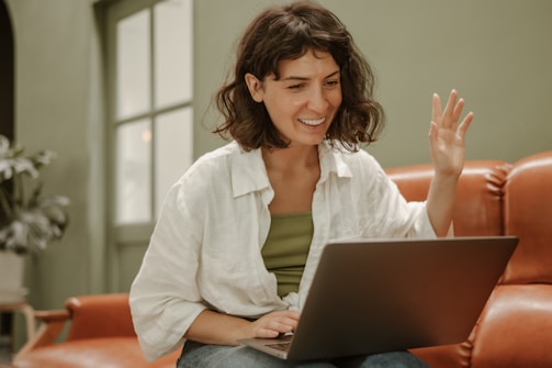 a woman sitting on a couch using a laptop computer