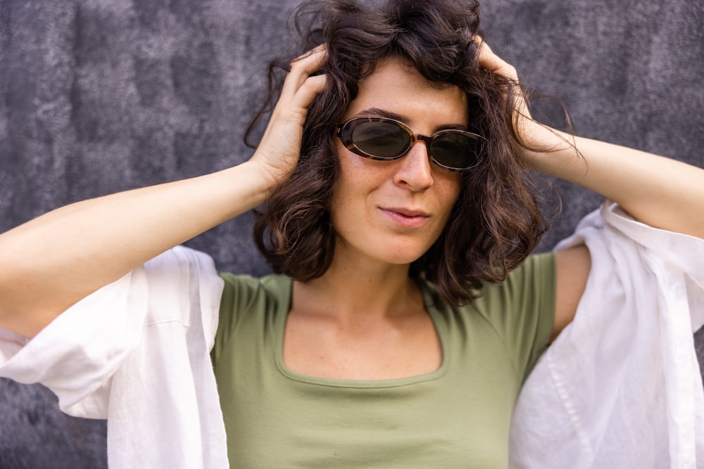 a woman wearing sunglasses and a green shirt