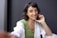 a woman sitting down talking on a cell phone