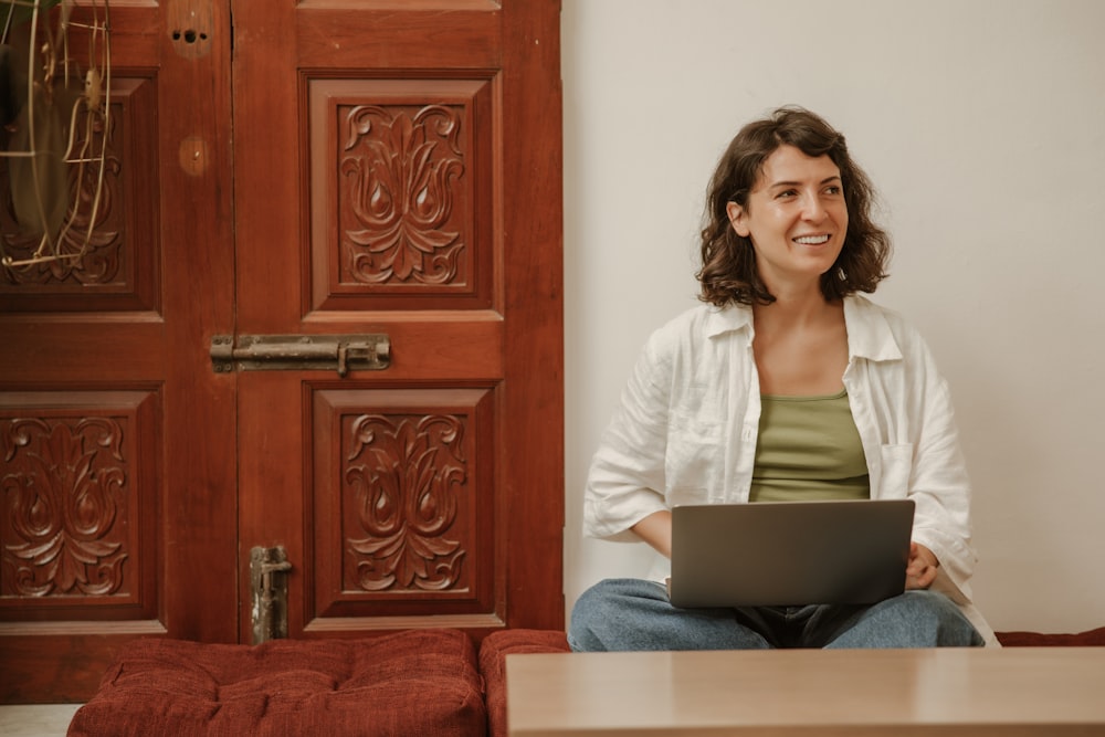 a woman sitting on a couch using a laptop computer