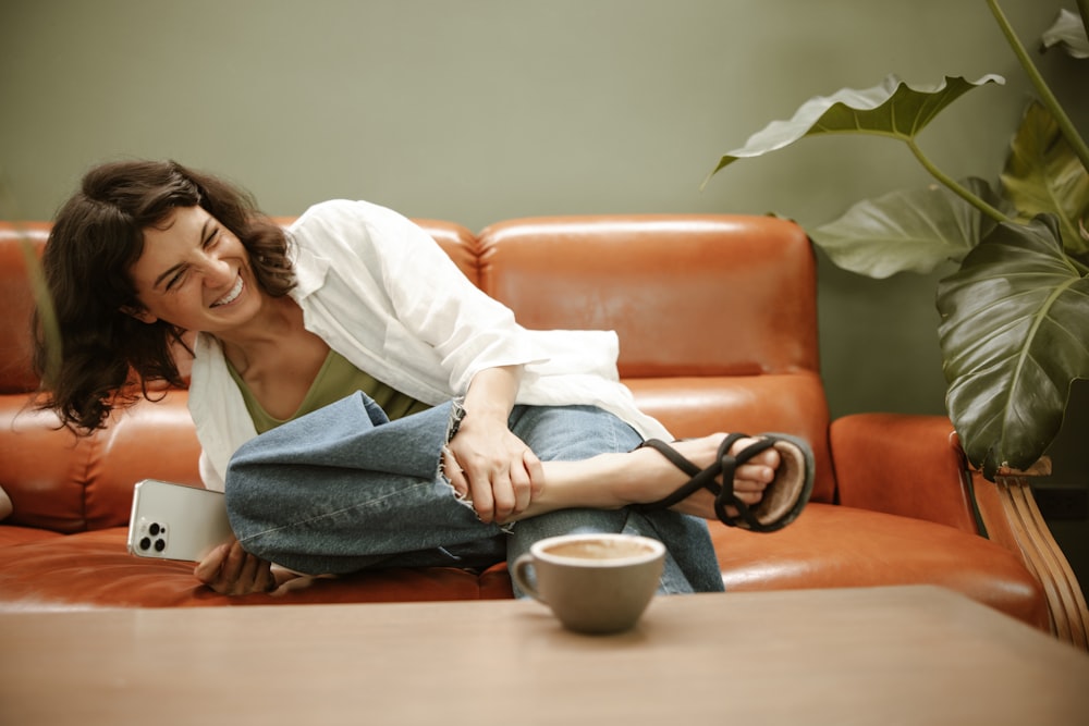 a woman sitting on a couch with a cup of coffee