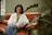 a woman sitting on a couch smiling for the camera