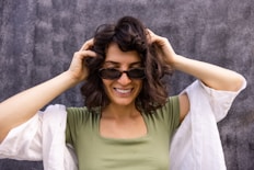 a woman wearing sunglasses and a green shirt