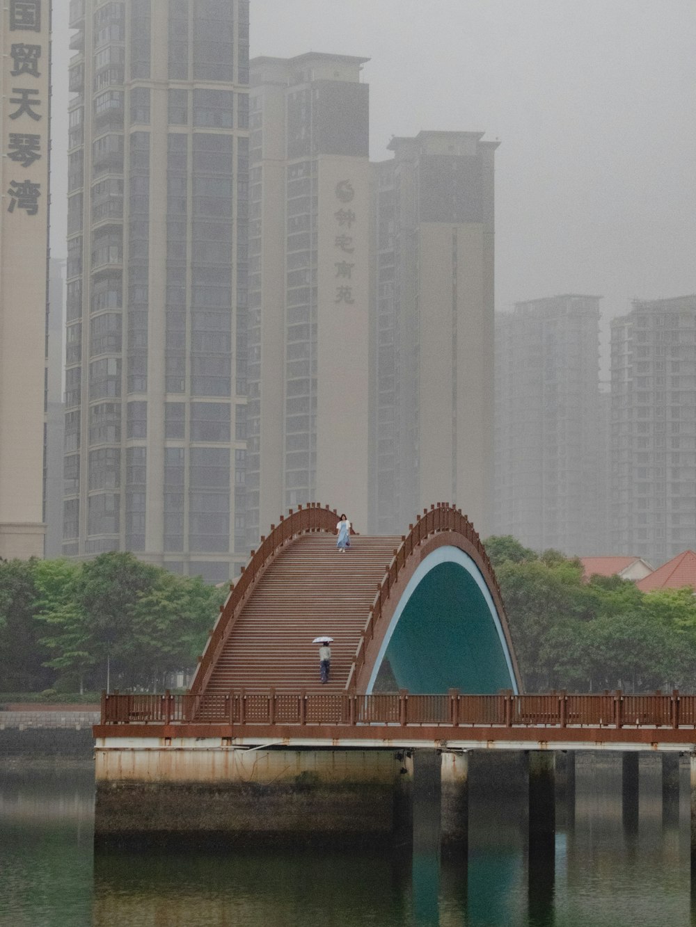 a bridge over a body of water with buildings in the background