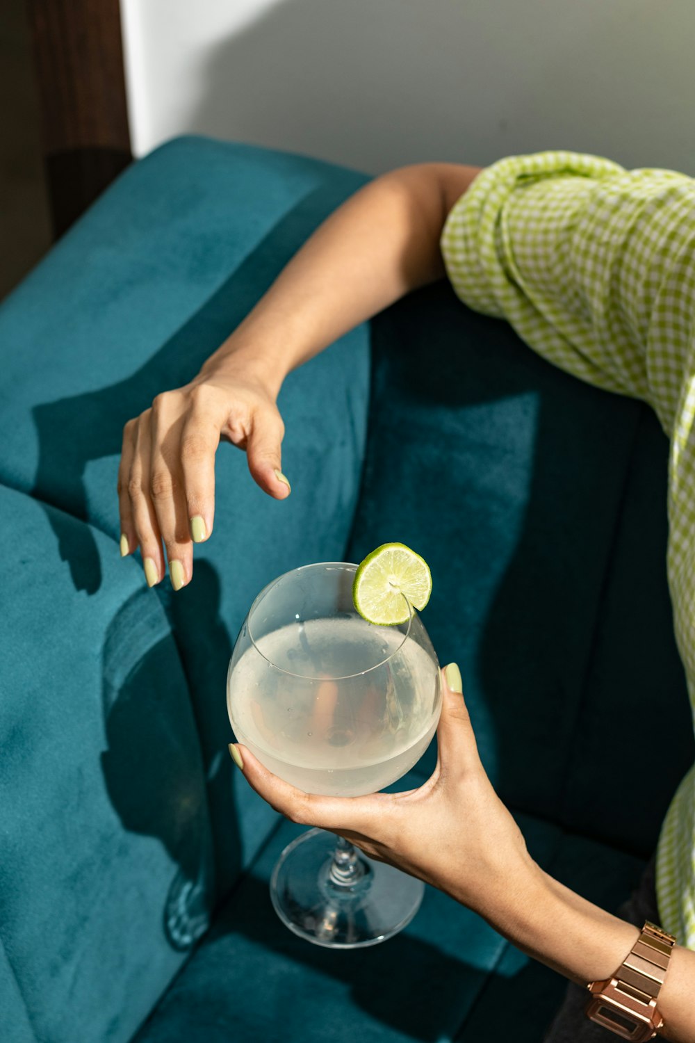 a woman holding a wine glass with a lime on it