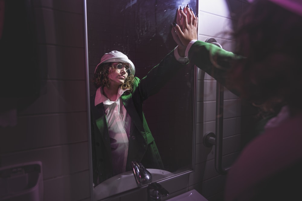 a woman standing in front of a bathroom mirror