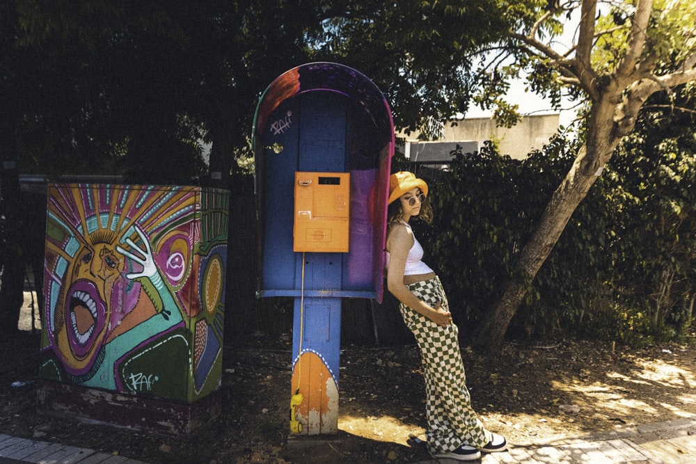 a woman standing next to a colorful mailbox