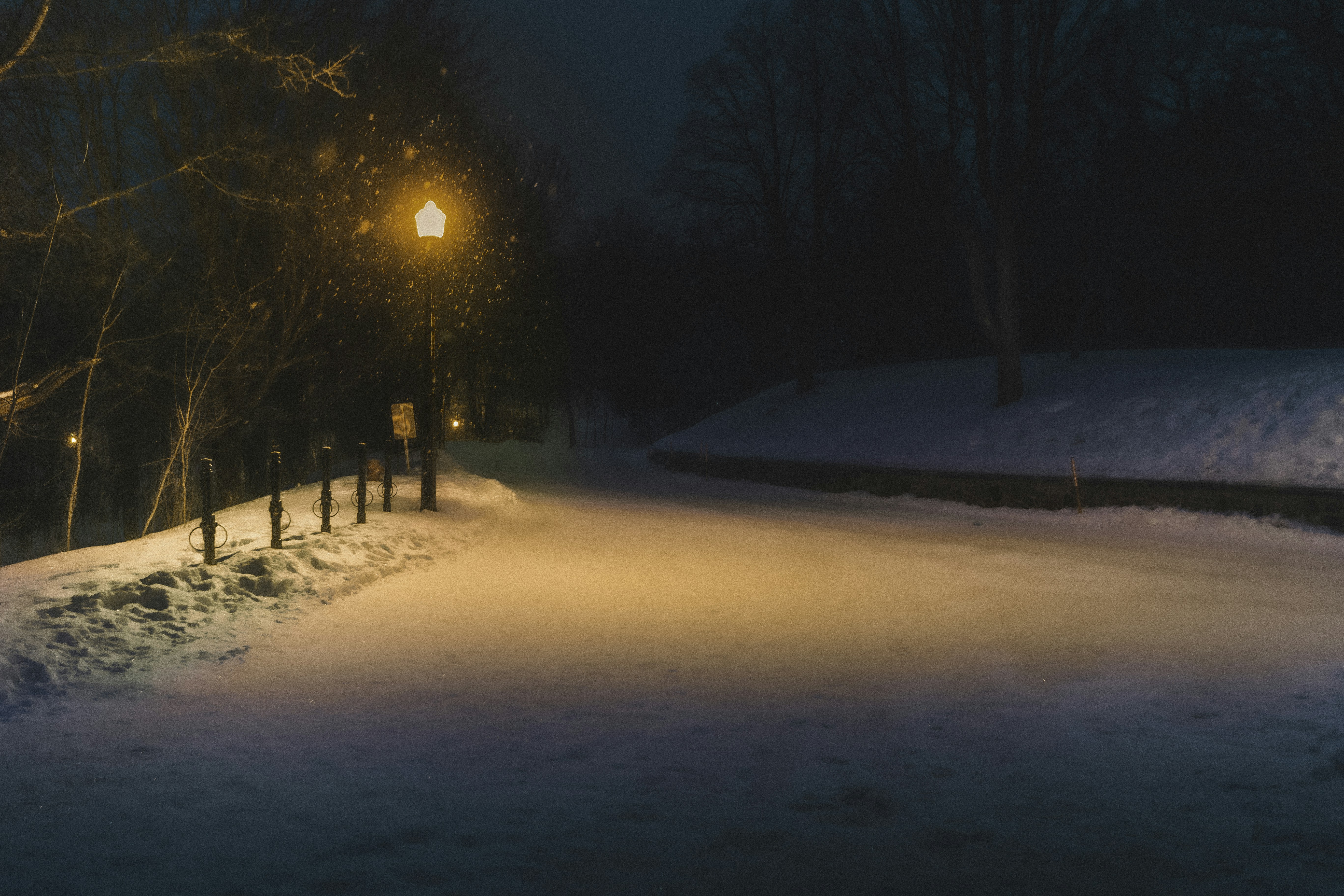 a street light on a snowy street at night