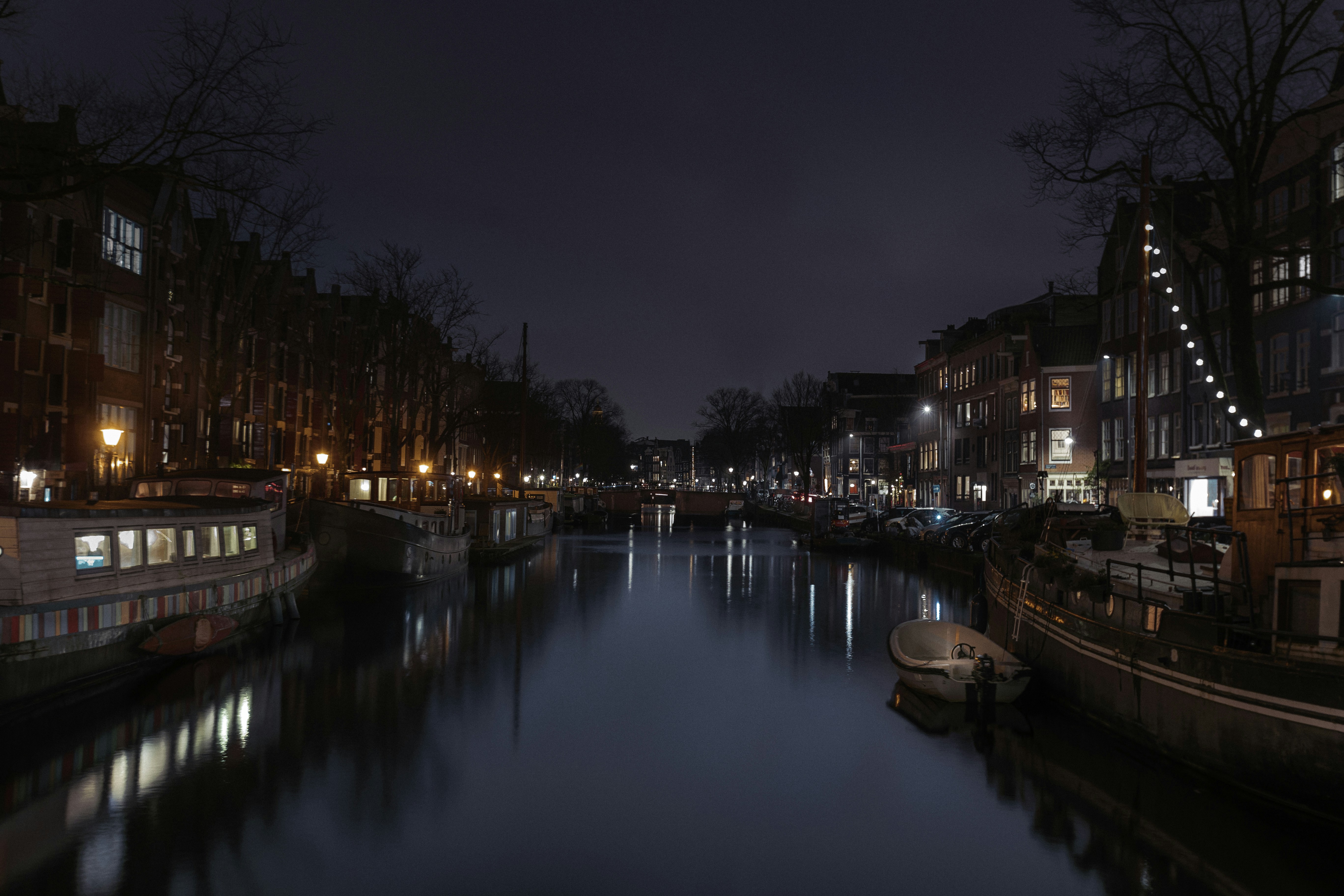 a canal at night filled with boats and buildings