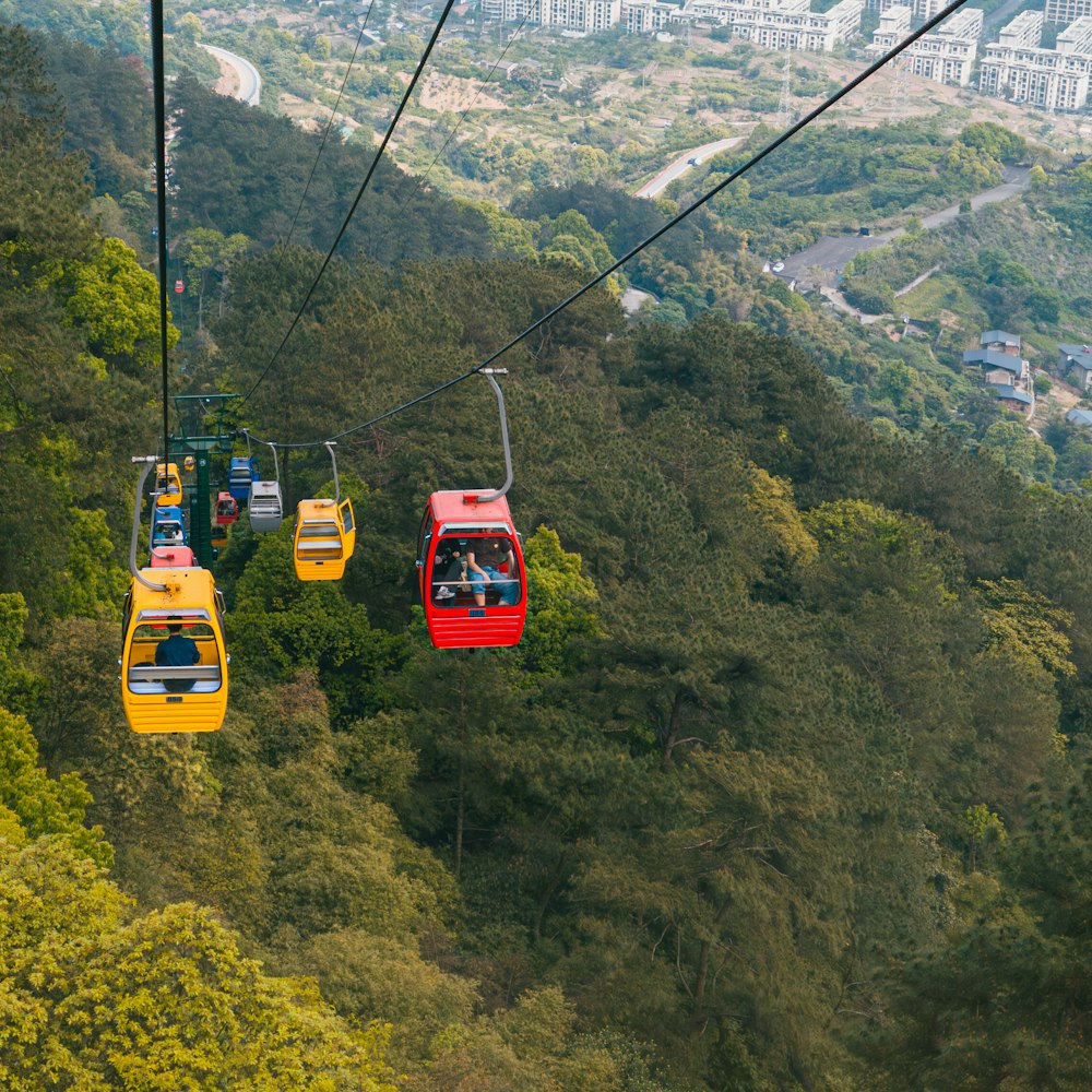 a group of people riding a cable car over a lush green hillside