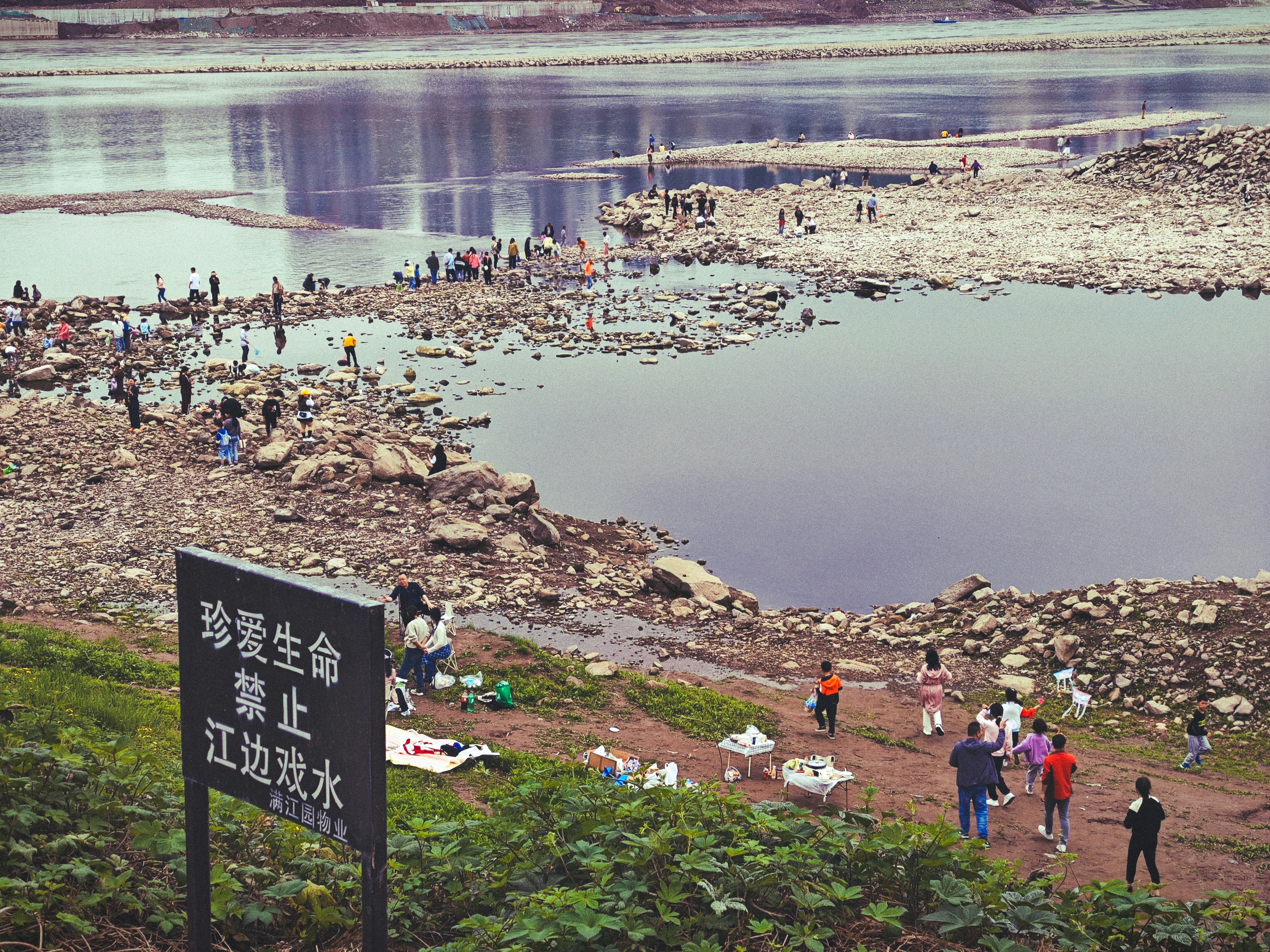 a group of people standing on top of a rocky beach