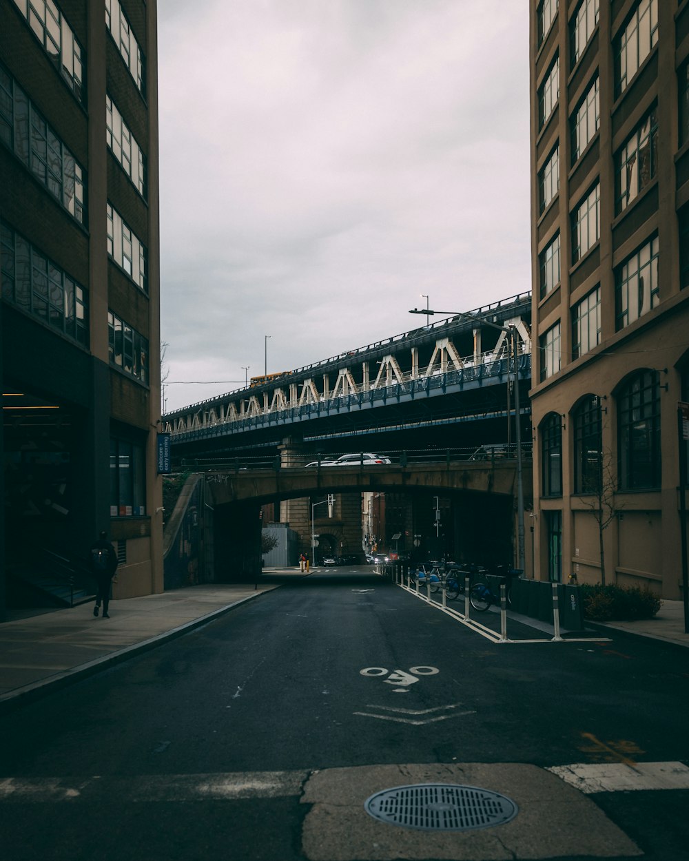 a street with a bridge over it next to tall buildings