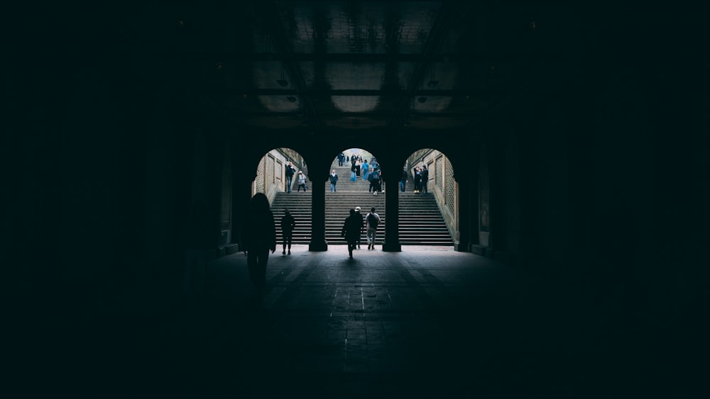 a group of people walking down a dark hallway