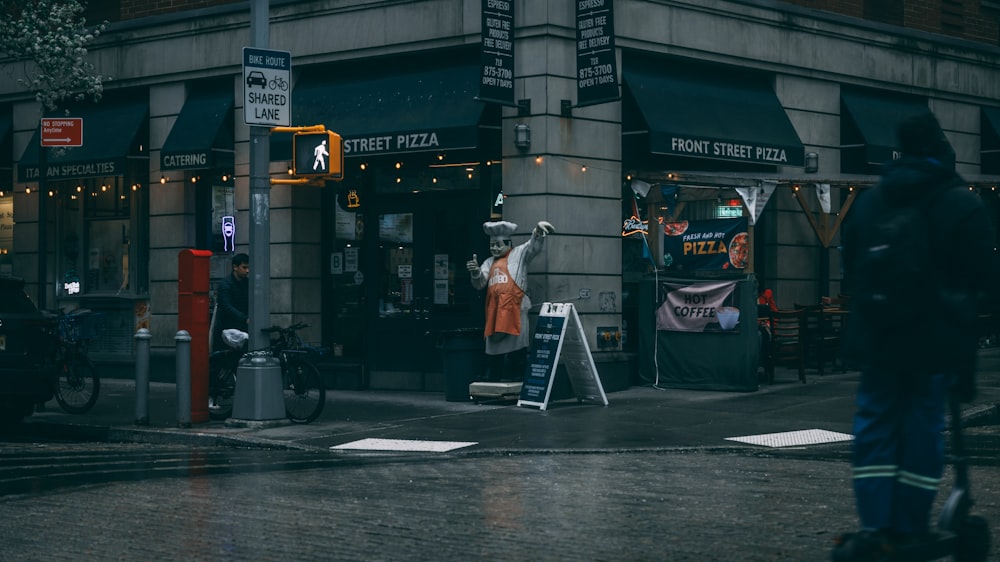 a person walking down a street next to a tall building