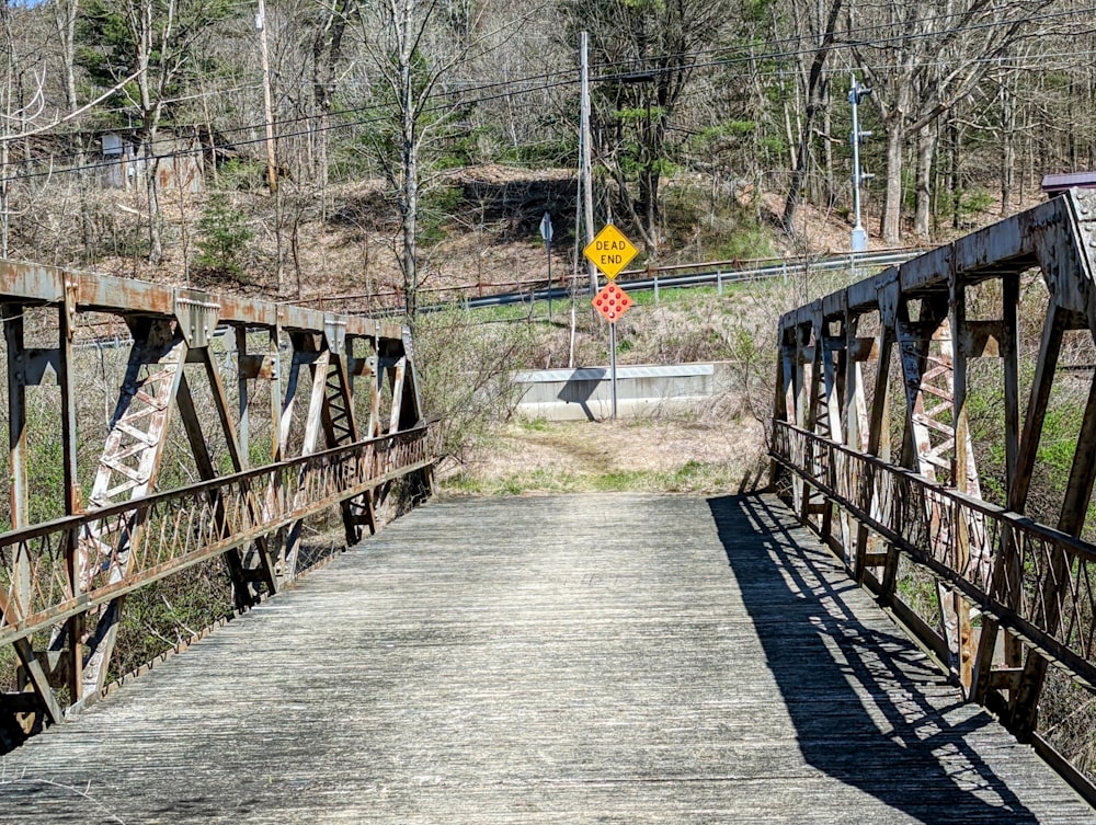 un viejo puente oxidado con un letrero amarillo