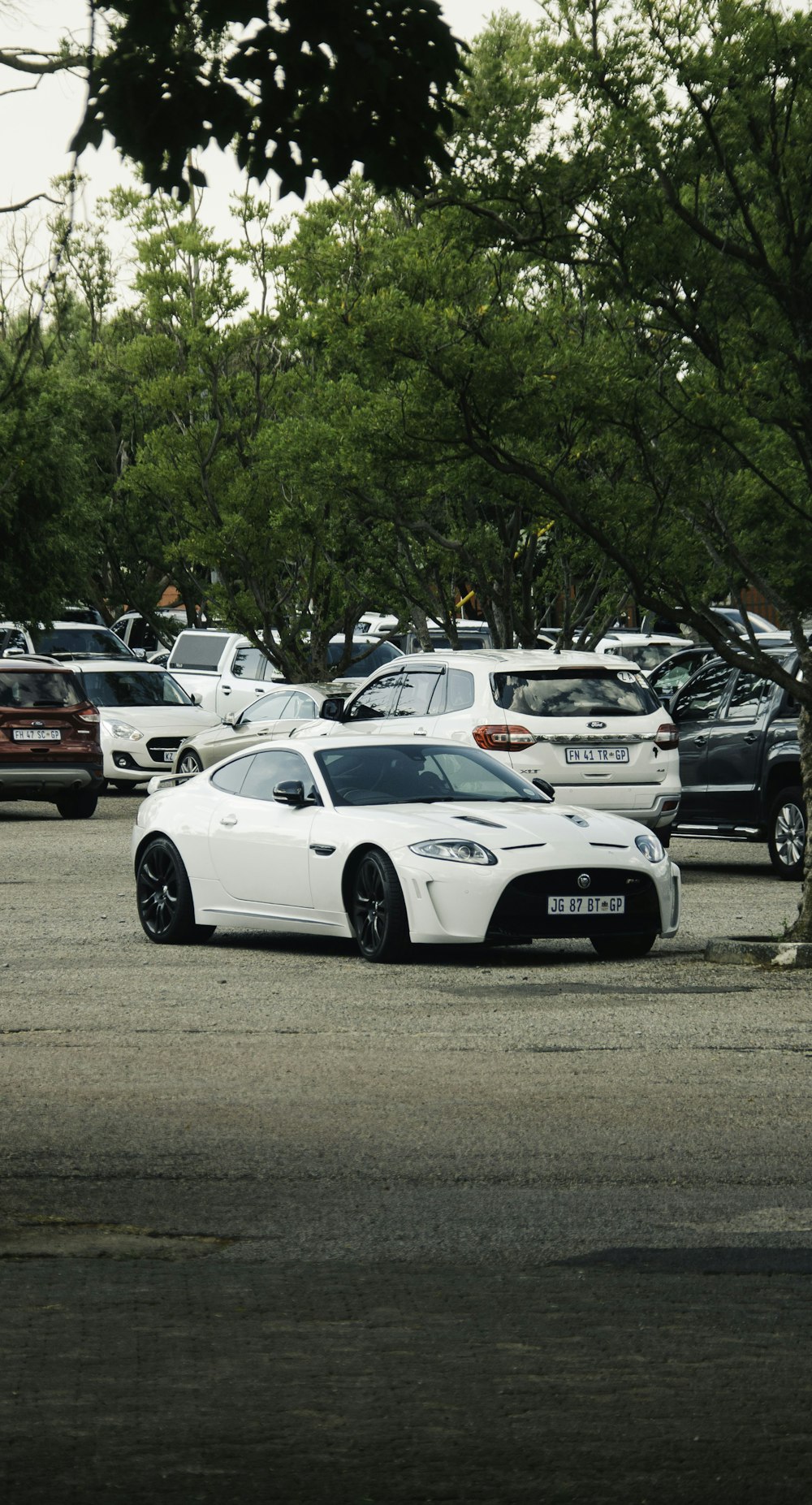 a white sports car parked in a parking lot