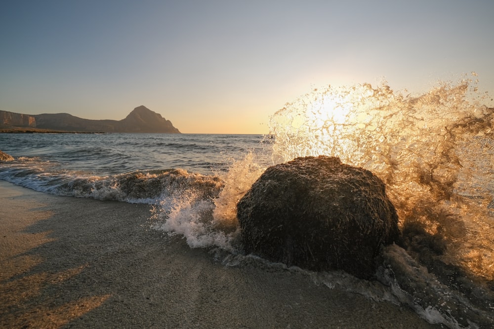 a large rock on a beach near the ocean