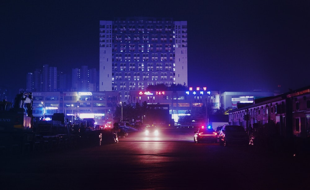 a city street at night with cars and buildings