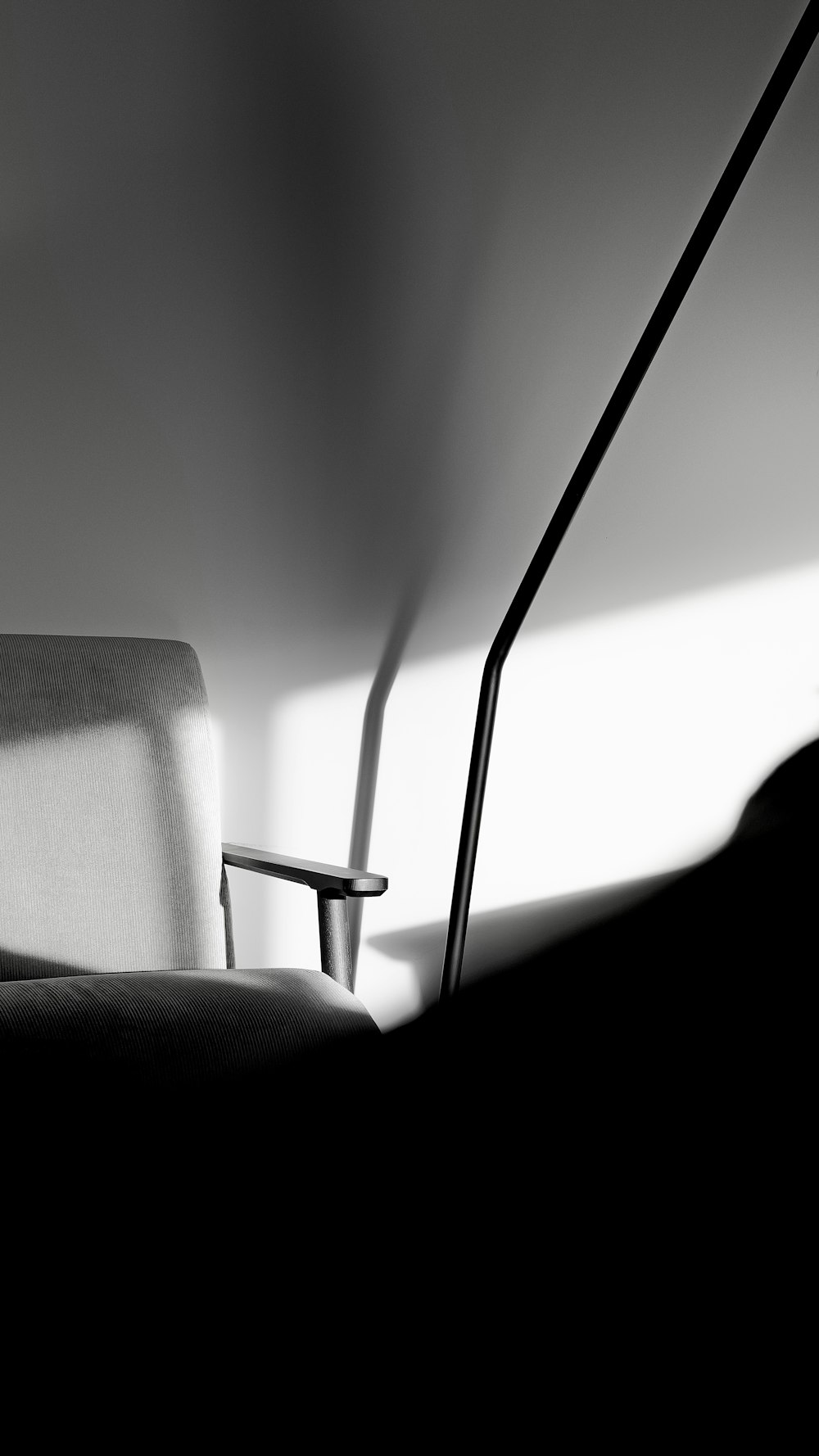 a black and white photo of a chair and a lamp