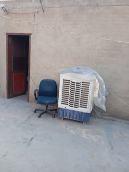 an air conditioner sitting next to an office chair