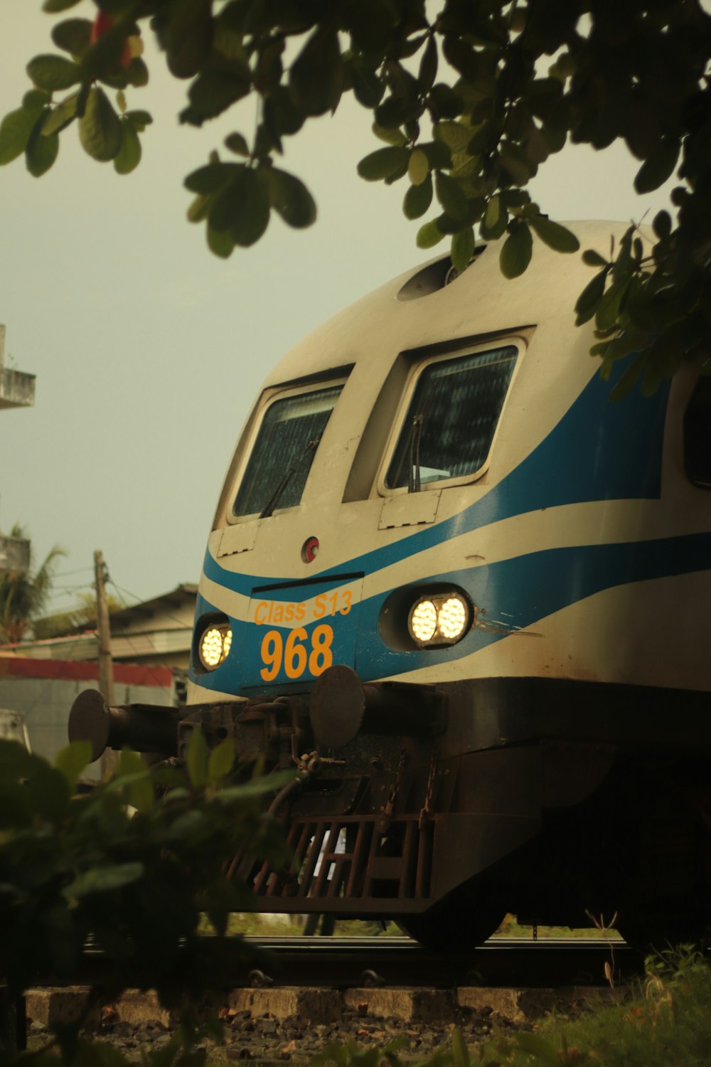 a blue and white train traveling down train tracks