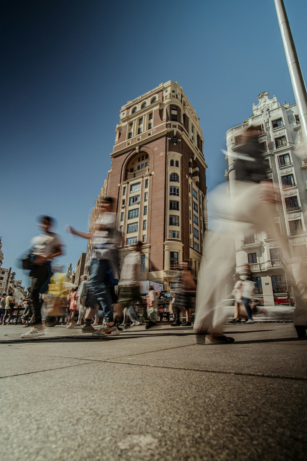 a group of people walking down a street next to tall buildings