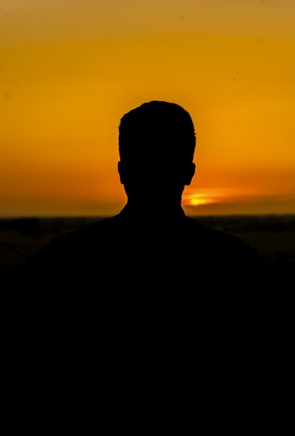 a silhouette of a man in front of a sunset