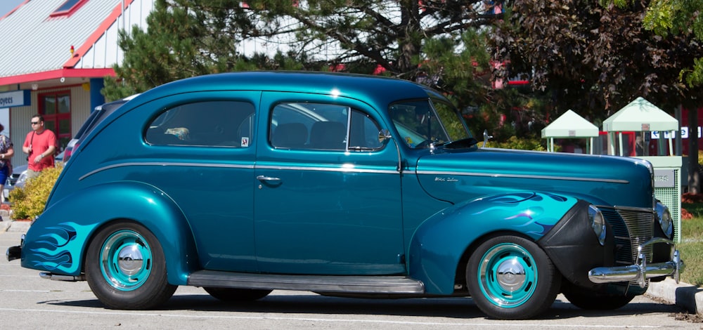 a blue classic car parked in a parking lot