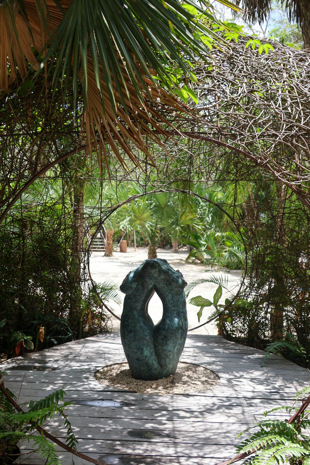 a sculpture in a park surrounded by trees