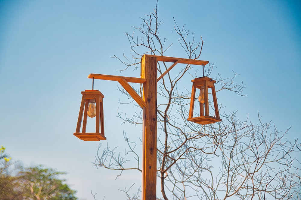 a wooden pole with two hanging lanterns on it