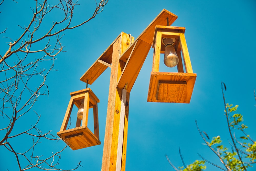 a couple of wooden lights hanging from the side of a tree