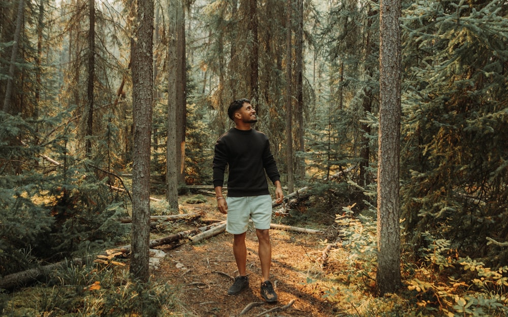 a man standing in the middle of a forest