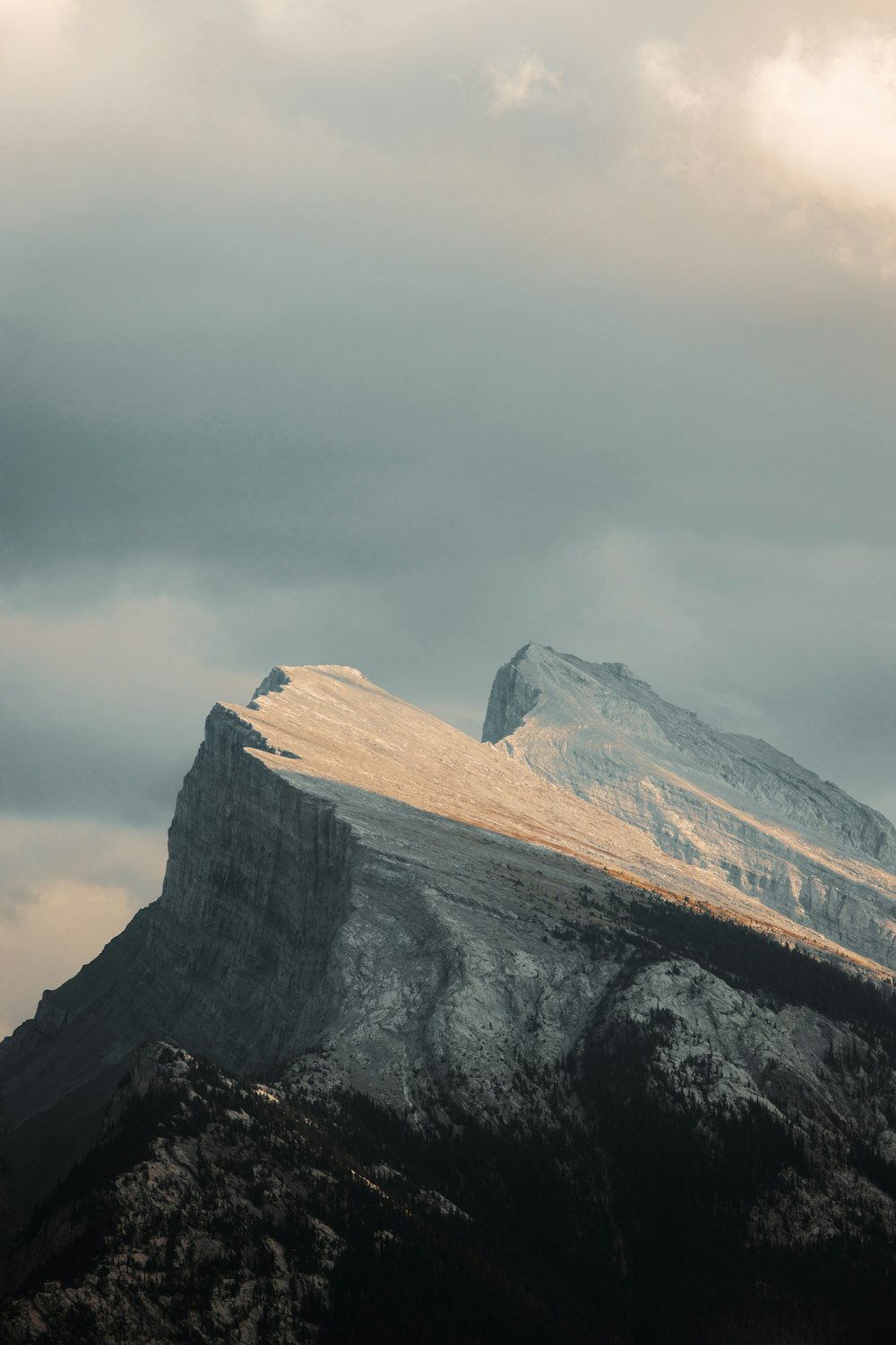 a snow covered mountain with a cloudy sky