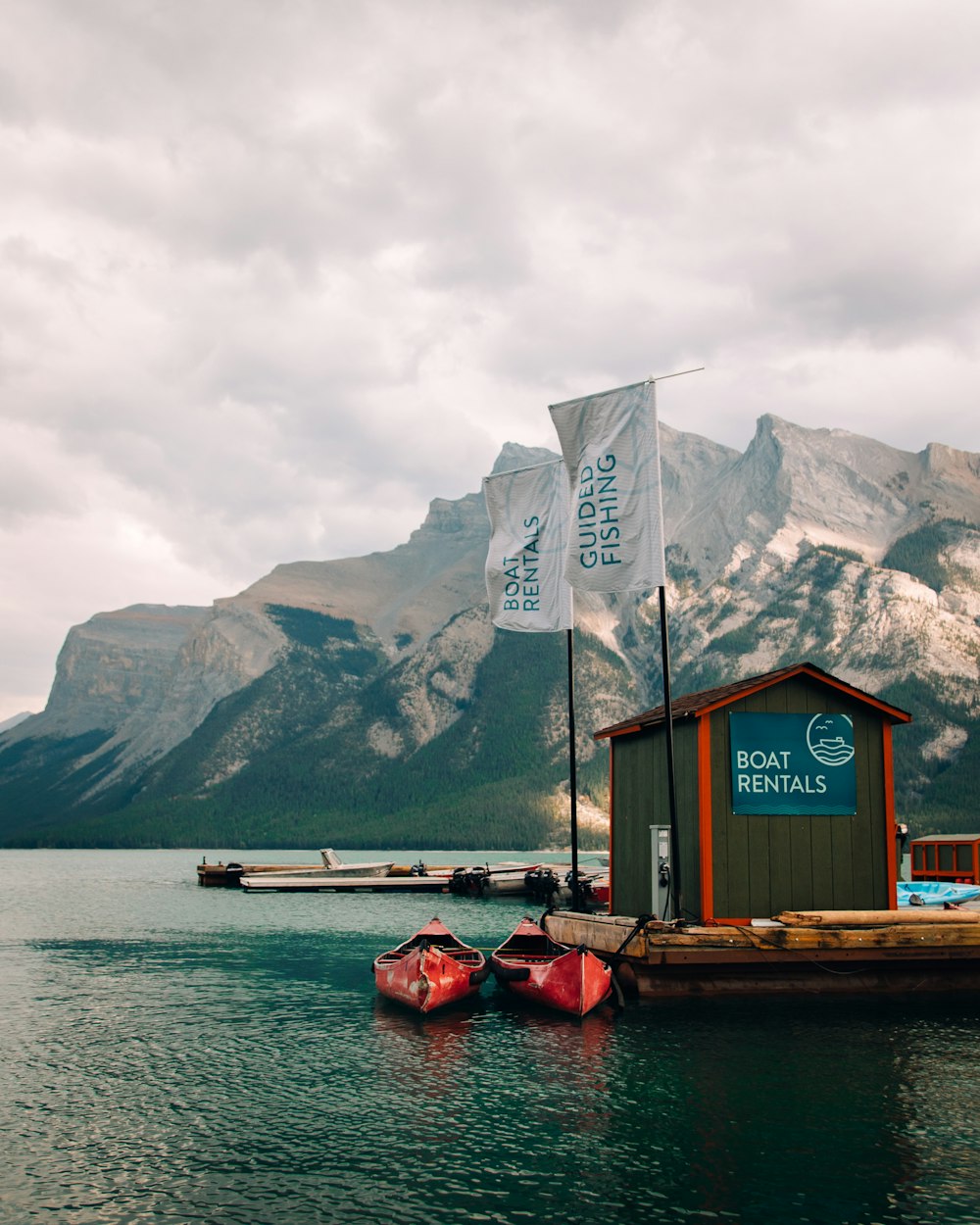 a boat is docked in the water with mountains in the background