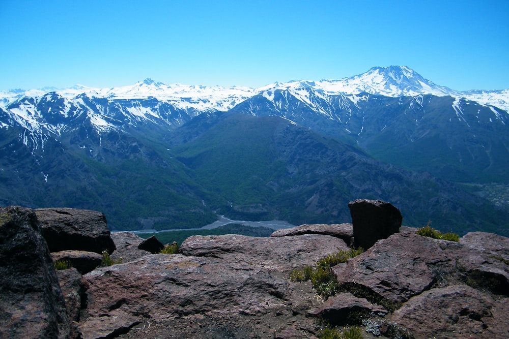 a view of a mountain range with snow capped mountains in the distance