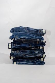 a stack of blue jeans sitting on top of each other