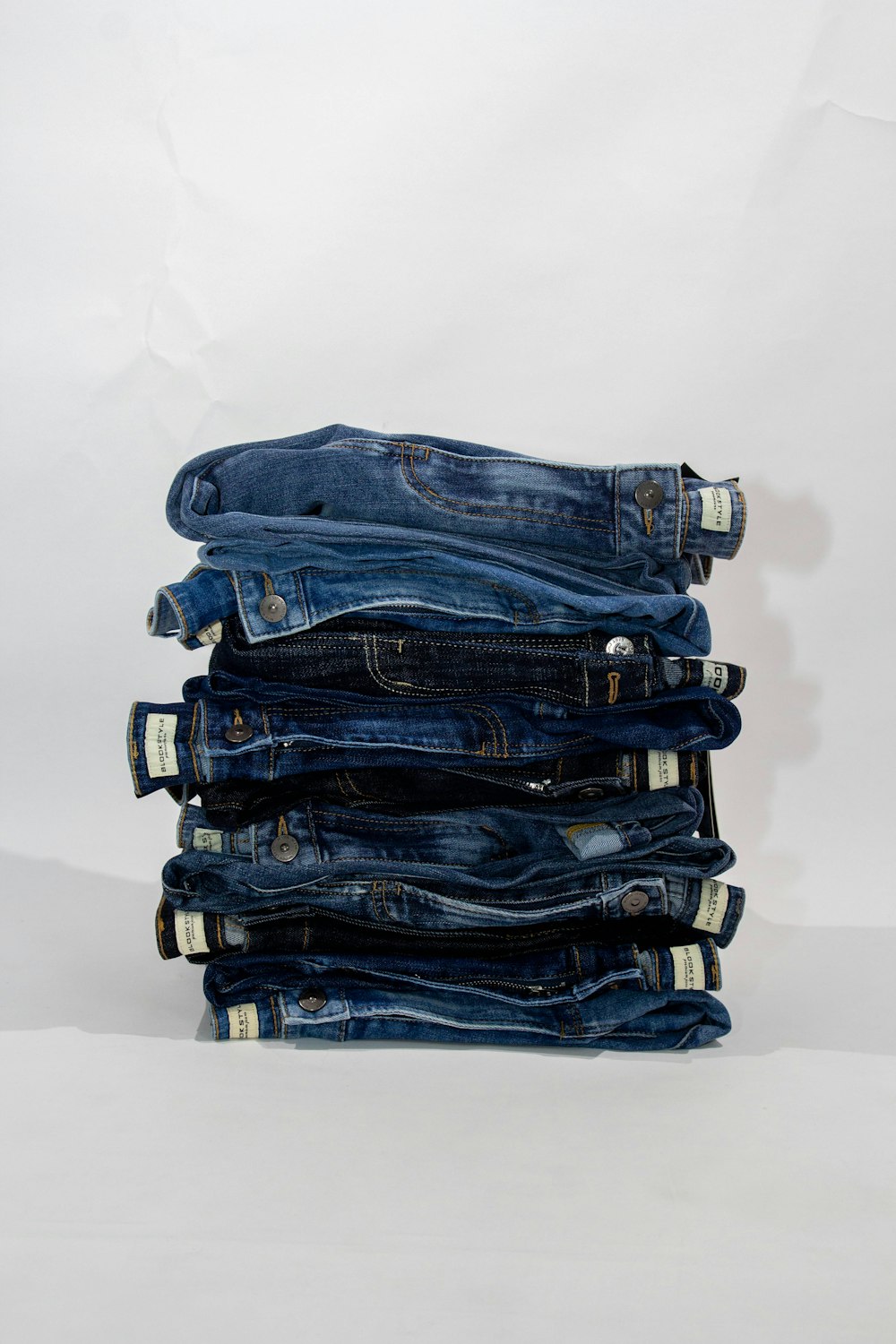 a stack of blue jeans sitting on top of each other
