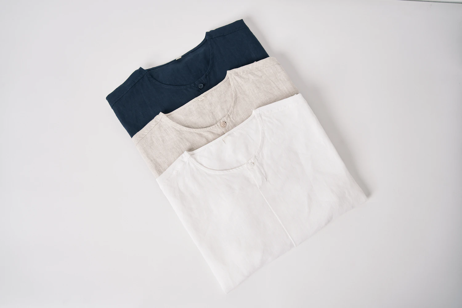 The Shop Tee Three-Pack, three folded tees in navy, stone and white