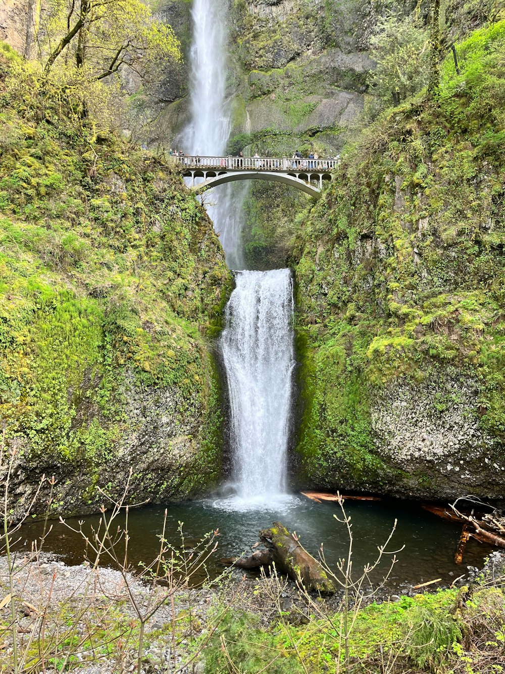 a large waterfall with a bridge over it