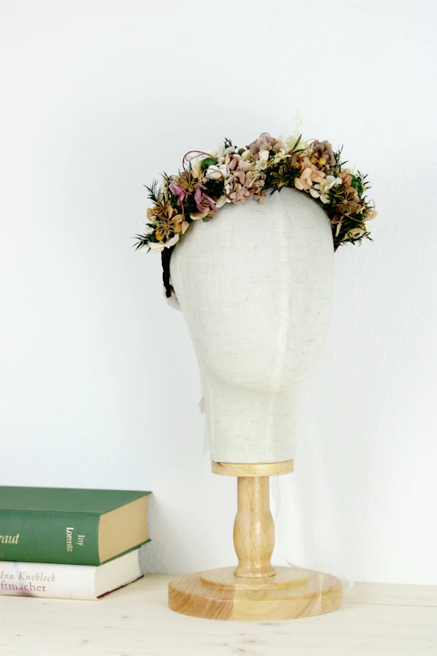 a white mannequin with a flower crown on top of it