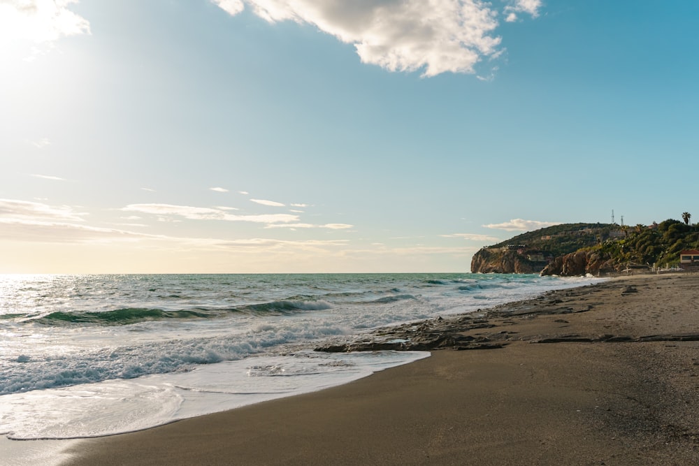 a sandy beach with waves coming in to shore