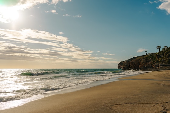 a sandy beach with waves coming in to shore