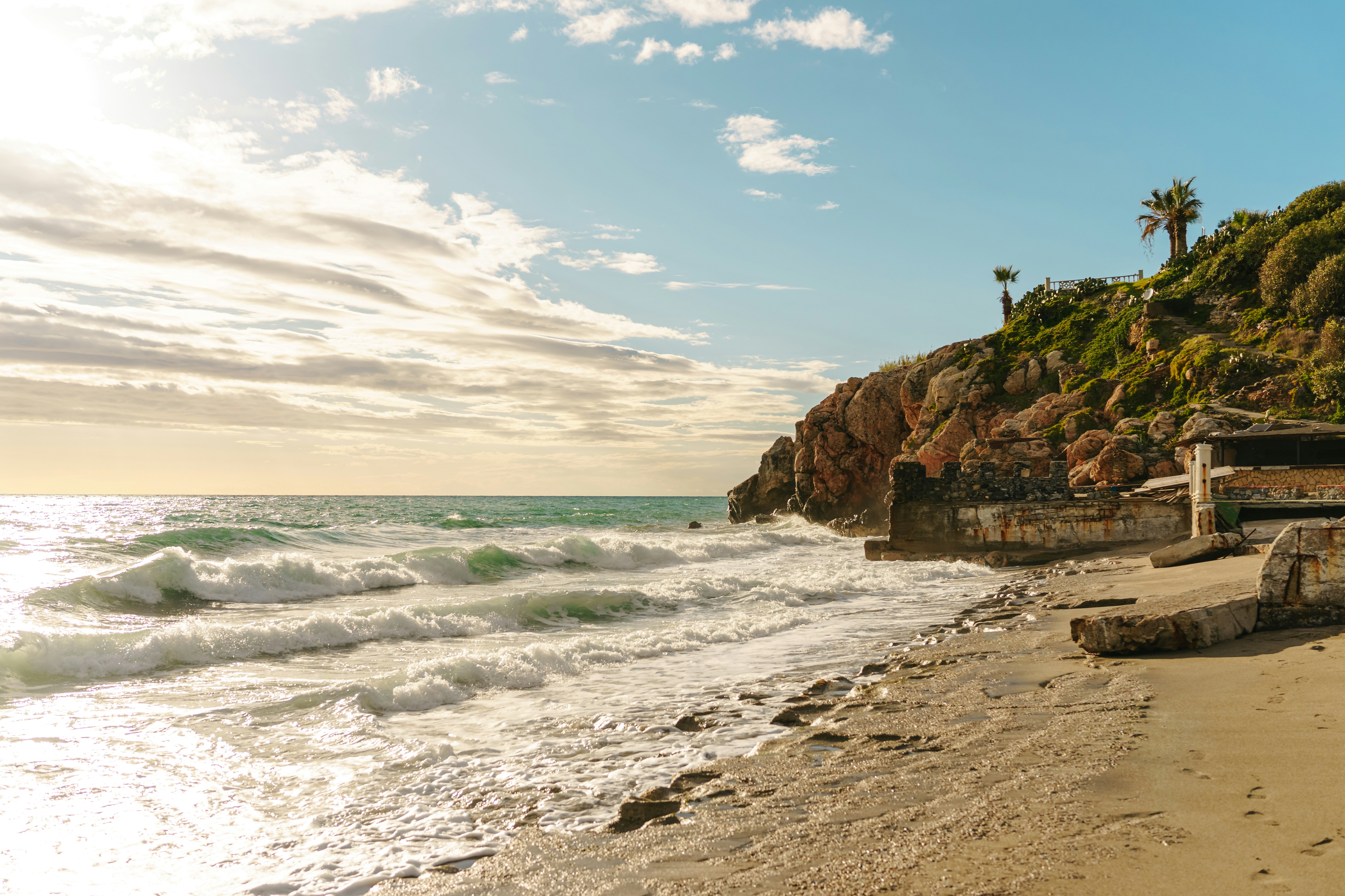 a sandy beach with waves coming in to shore