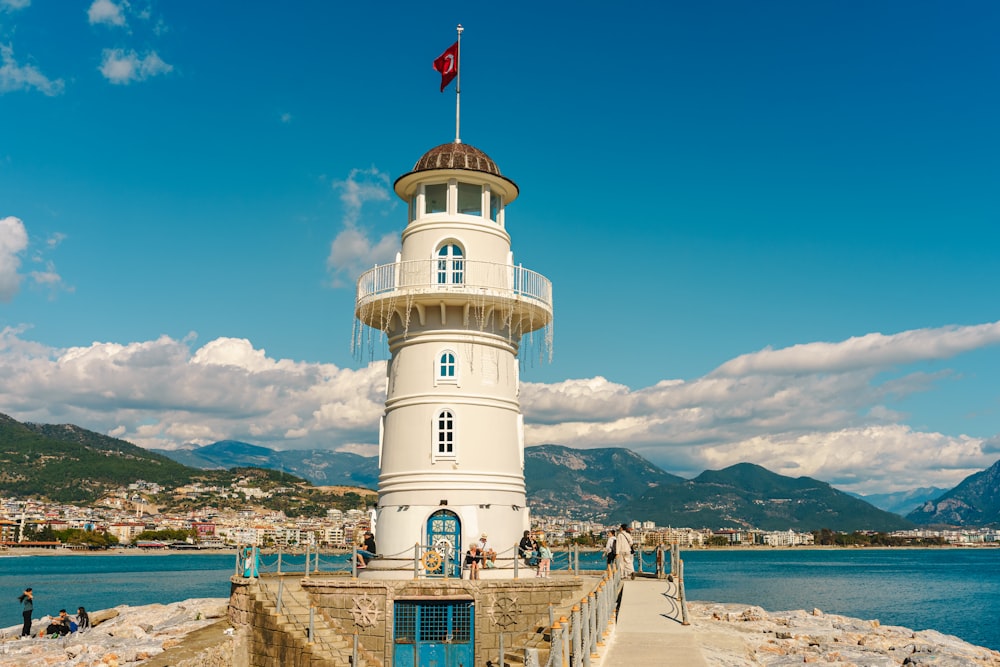 a white lighthouse with a flag on top of it