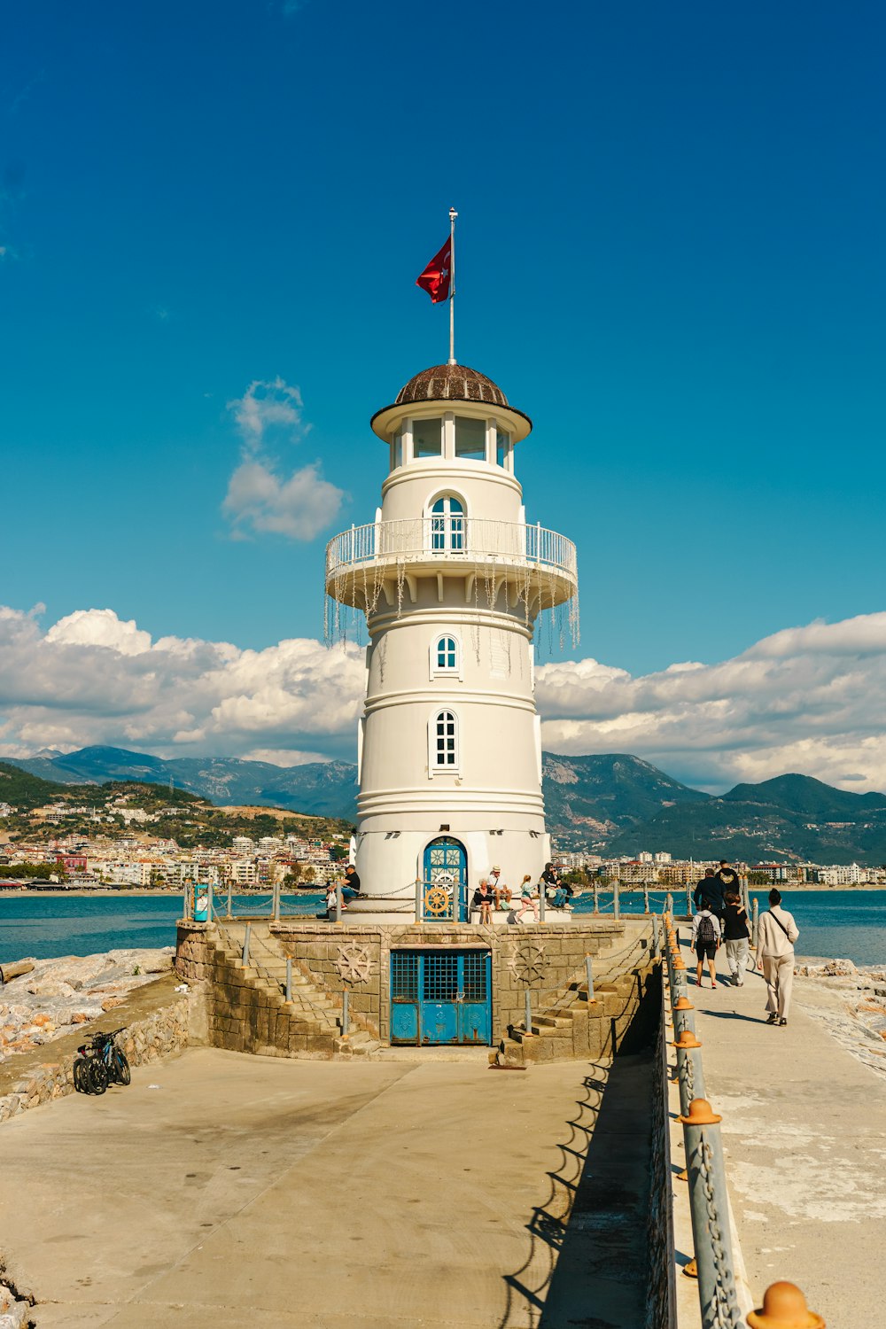 a white lighthouse with a flag on top of it