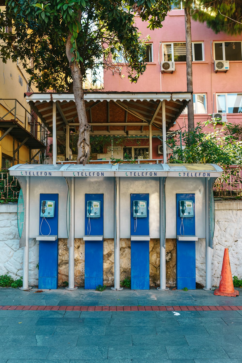 a row of blue doors sitting next to a tall building