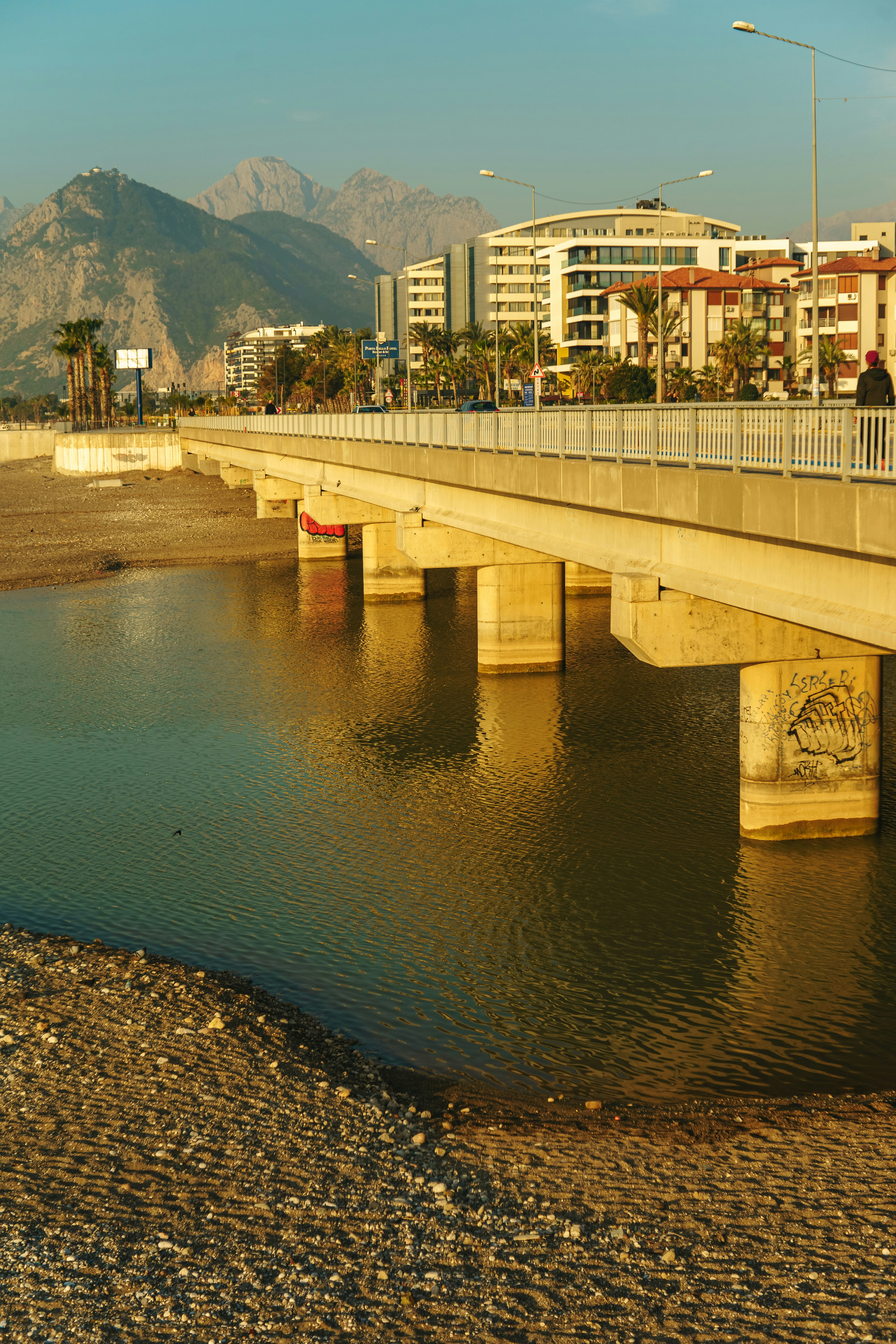 A bridge over a body of water with buildings in the background photo ...