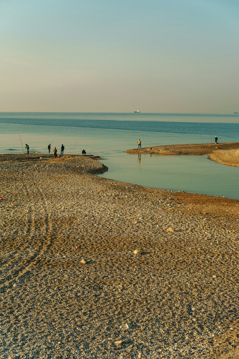 a group of people standing on top of a sandy beach